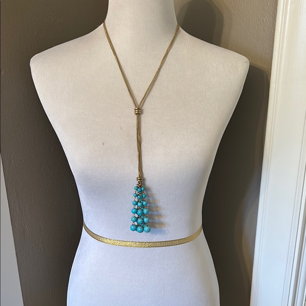 Statement gold tone and turquoise colored beaded tassel necklace